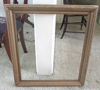 Full view of rectangular gold gilt wooden frame standing upright