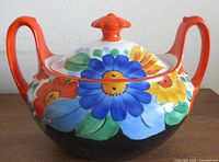 Front view showing floral design, lid and both handles