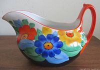 Right side view of porcelain creamer showing floral artwork and handle