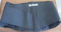 Front view of black McDavid back support belt showing logo and wrap style