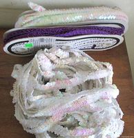 Purple and clear iridescent sequin trims on card and in coil