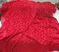 Full view of red velvet jacquard fabric draped showing pattern