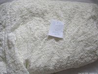 Full view of folded ivory stretch lace fabric with note indicating 3+ yards