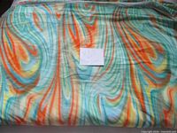 Full view of folded multicolour swirl stretch fabric with note indicating 8+ yards