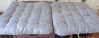 Two gray tufted seat cushions on table