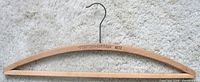 Full view of wooden hanger showing brand stamp and hook