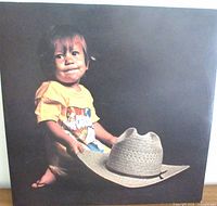 Front of sleeve with child holding cowboy hat