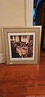 Full view of framed print leaning against wall
