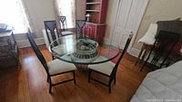Overall view of round glass table with urn base and six matching chairs