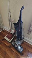 Two upright vacuums side by side, Kirby on right, Hoover on left