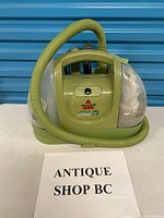 Front and side view of cleaner showing overall form, hose and tanks