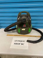 Front view showing Bissell Velocity canister vacuum with hose attached