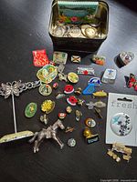 entire lot showing tin and spread of pins, brooch and butterfly stand