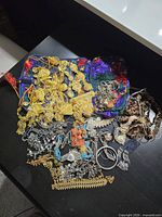 Overview of entire mixed jewelry lot on black table