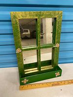 Full view of green wooden window-style mirror showing four panes, ledge, ruler for scale