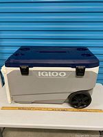 Right side view showing Igloo logo, wheels, latches, ruler for scale