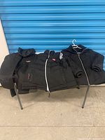 Three black outerwear pieces on table