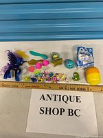 Full lot with ruler for scale showing main figures, sealed Smurfs toy, Kinder capsule and mini accessories