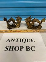 Both dragon figurines side by side with ruler for scale