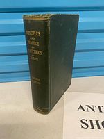 Spine and cover of the green cloth hardcover book showing title and edition