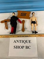 Both marionette dolls, three controller parts, measuring stick for scale