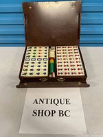 Mahjong set open in brown case showing tiles, dice and sticks