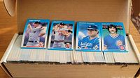 Open factory box showing rows of 1987 Fleer baseball cards and example player cards displayed on top