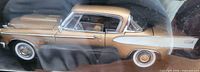 Model car inside packaging showing gold and white Studebaker Golden Hawk