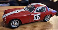 Left front view of red 1960 Lotus Elite model showing racing number 37 and wire wheels