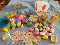 group shot of all Easter decorations including eggs, buckets, baskets, figurines, tin train, metal pig stake, cardboard rabbits