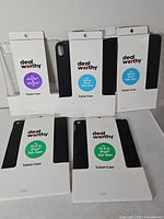 Group shot of five sealed Dealworthy tablet cases showing packaging fronts