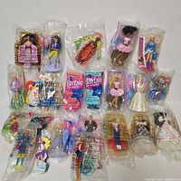 Full lot overview showing ~20 sealed Barbie Happy Meal toys