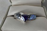 Ring front view showing purple center stone and clear accents