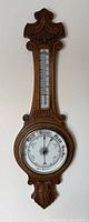 Full view of carved oak wall barometer and thermometer