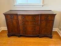Front view of mahogany sideboard showing drawers, doors, hardware, feet