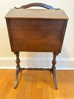 Front view of walnut sewing cabinet on turned legs