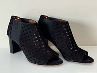 Side three-quarter view of both boots showing suede material, perforations, heel style