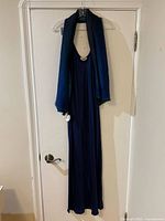 Full view of dark blue satin slip dress with scarf draped over hanger