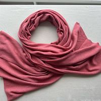 Full view of rose pink cashmere wrap shawl laid out and loosely coiled