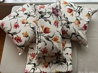 Three cushions stacked on folded fabric showing matching tulip print