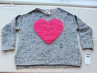 Front view of grey sweater with pink heart