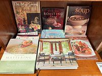 Shelf view of nine visible book covers including Williams-Sonoma titles, Soup, Spectacular Homes, Meat & Seafood