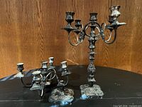 Both silver plate candelabras on table