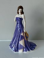 Full view of Claire figurine showing dress, pose and hat