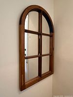 Side angle of the arched pine mirror hanging on wall