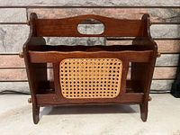 Front view of walnut magazine rack showing cane panel and overall structure