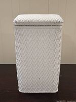 Front view of closed white wicker hamper