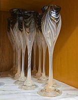 Group of tall feather pulled champagne glasses on shelf