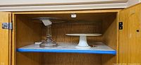 Both cake plates inside cupboard