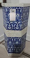 Full view of hexagonal blue and white porcelain umbrella stand with tag visible